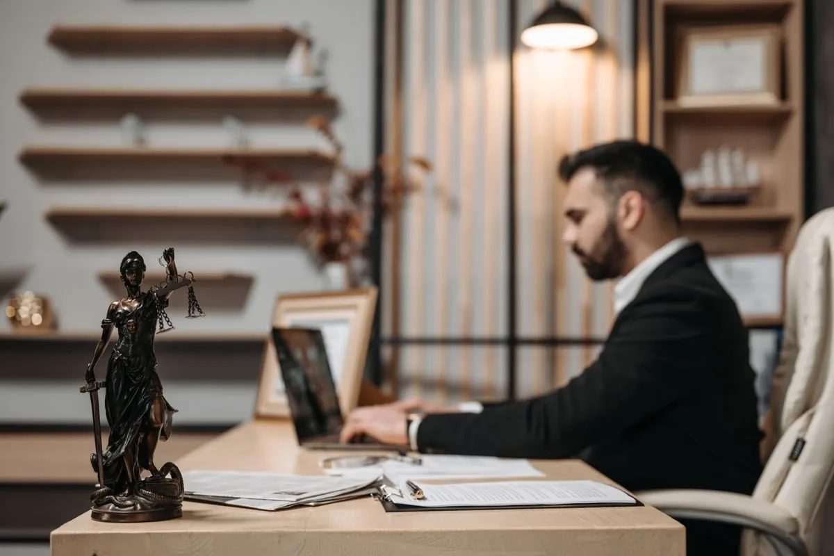 Lawyer working at a desk with a Lady Justice statue