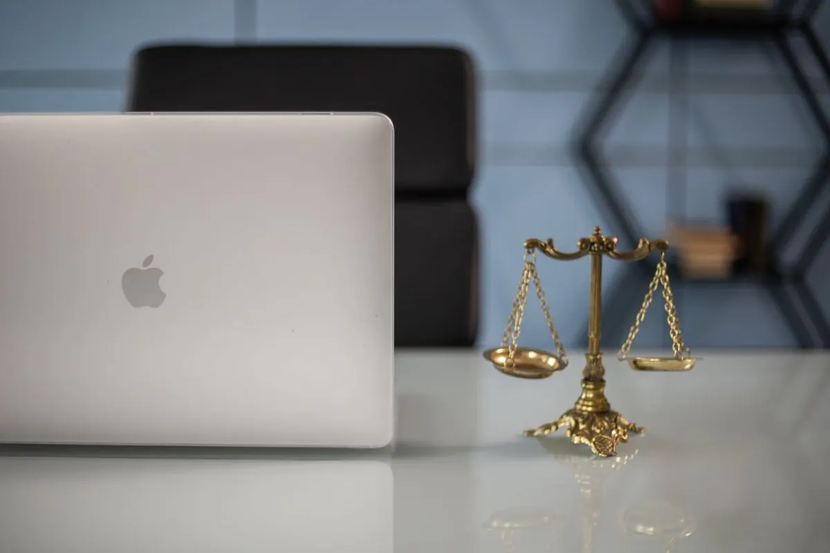 Scales of justice next to a laptop in a law office