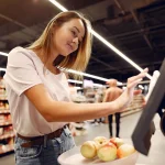 Shopper using a self checkout point of sale screen in a grocery store, Square vs KORONA POS